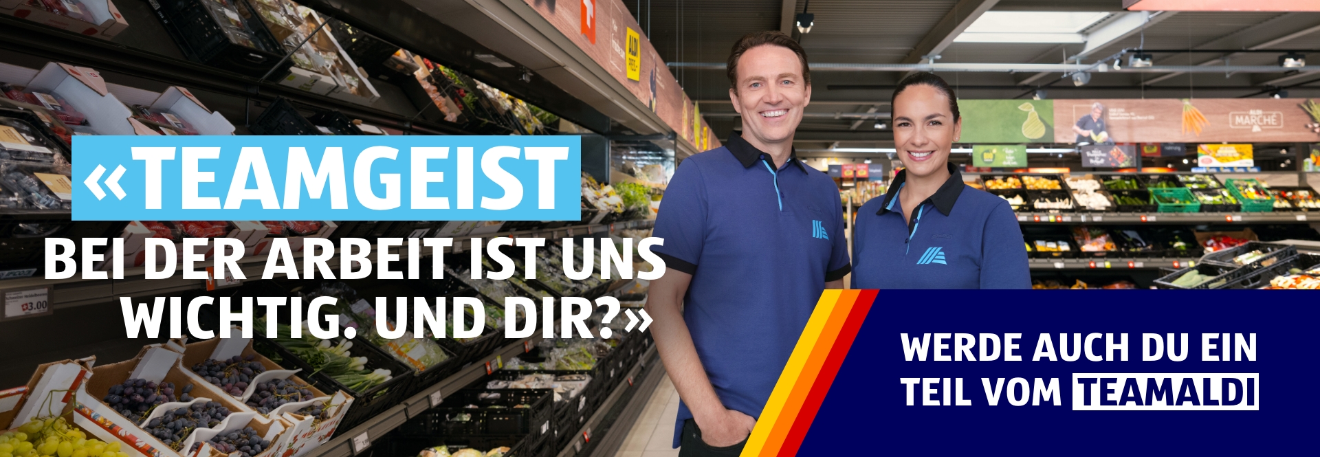 Zwei Personen ein Mann und eine Frau stehen in der ALDI Filiale nebeneinander und lächeln. Auf der Bildüberschrift steht: Teamgeist – Bei der Arbeit ist uns wichtig. Auf der Bildüberschrift steht: Teamgeist – Bei der Arbeit ist uns wichtig. Du auch? Werde