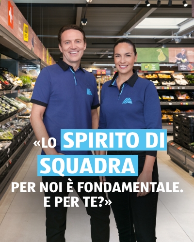 Due persone, un uomo e una donna, sono l'uno accanto all'altra nella filiale ALDI e sorridono. La didascalia della foto recita: Lo spirito di squadra sul lavoro è importante per noi. La didascalia della foto recita: Lo spirito di squadra sul lavoro è importante per noi. E per te?