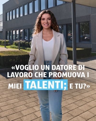 Donna in piedi e sorridente davanti alla Sede centrale di ALDI Suisse. La didascalia della foto recita: Voglio un datore di lavoro che promuova i miei talenti. E tu?
