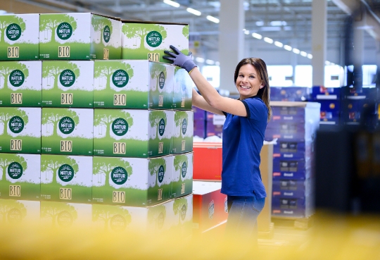 Eine Mitarbeiterin kommissioniert Produkte aus dem Sortiment von ALDI Suisse.